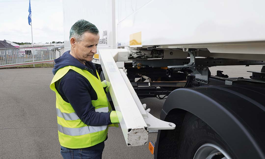 Mitarbeiter klappt die Beine eines Wechselbehälters aus
