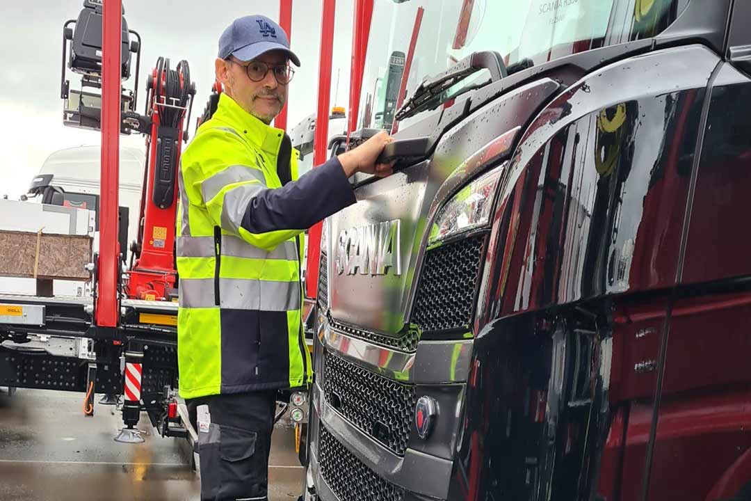 Mann reinigt Frontscheibe eines Lkw