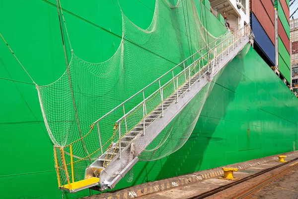 Gangway führt von Kai auf ein grünes Schiff