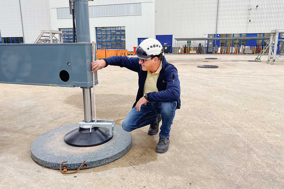 Zertifizierte Prüfsachverständige dürfen Autokrane prüfen Ein Sachverständiger schaut sich den Hydraulikzylinder einer Kranstütze an.