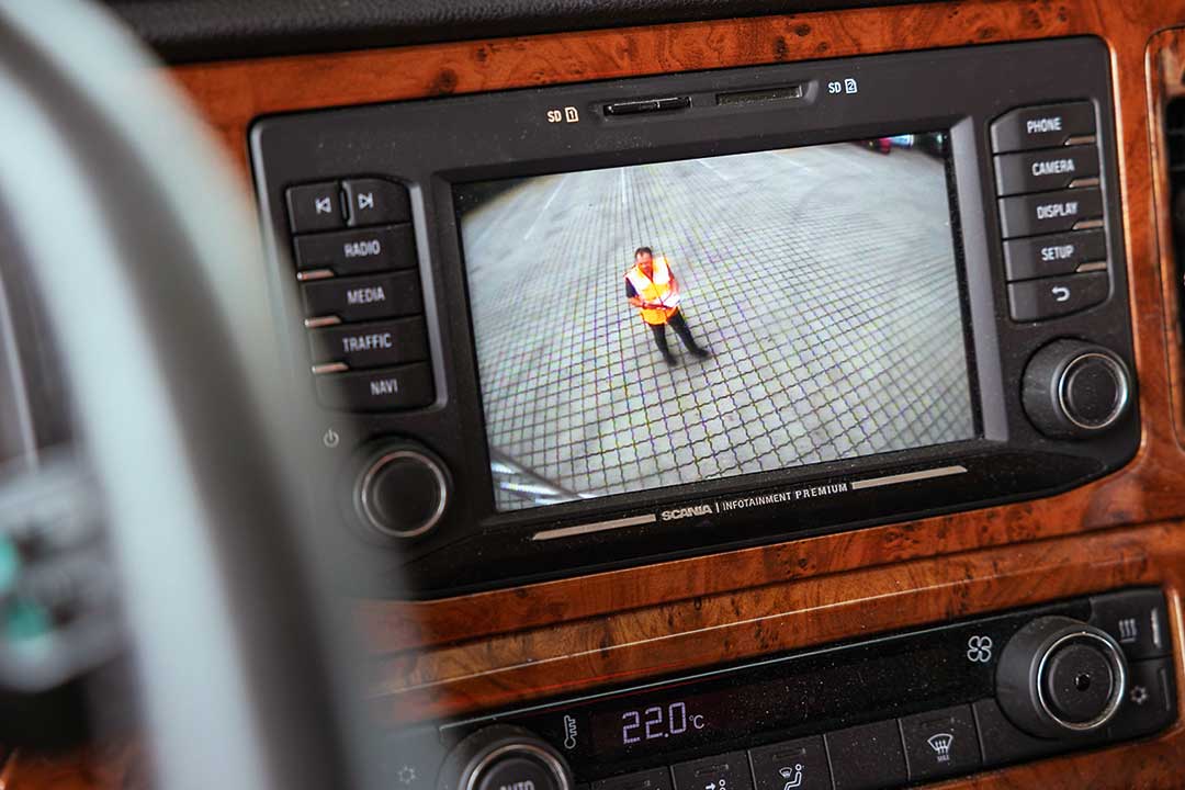 Rückfahrkameras sorgen für bessere Sicht nach hinten Das Display eines Kamera-Monitor-Systems zeigt eine Person, die hinter dem Fahrzeug steht.