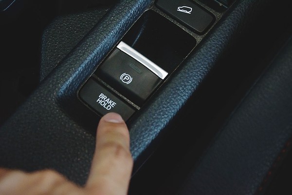 Finger drückt die elektronische Feststellbremse