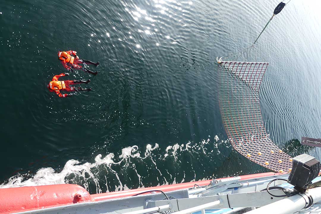 Blick von Bord des Spezialschiffs auf zwei "verunglückte" Personen im Wasser.