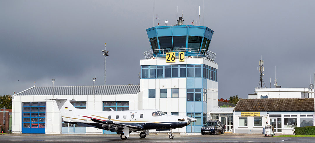 Blick von der Start- und Landebahn aus auf den Tower des Flughafen Kiels