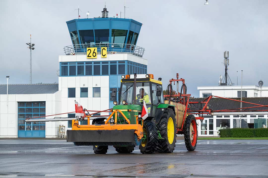 Sprühgerät auf der Landebahn vor dem Tower