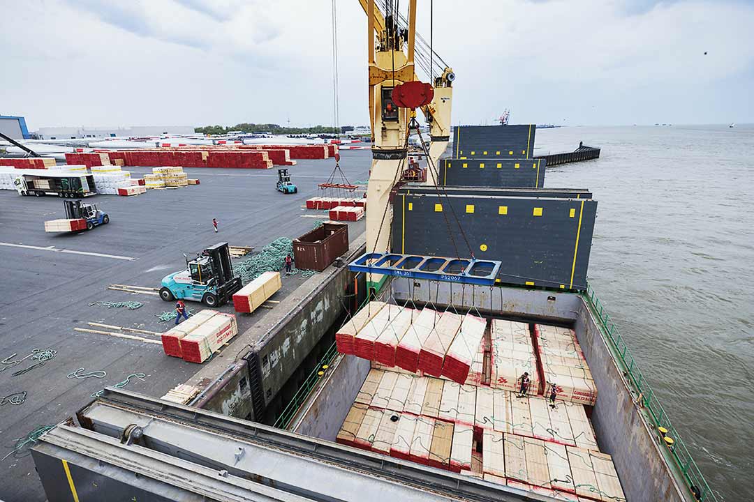Ein Schiff wird mit Hebezeugen am Hafen beladen