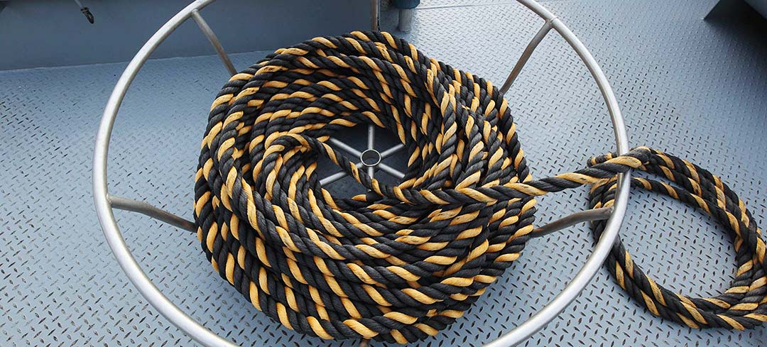 Aufgerolltes Tau in einem Taukorb an Deck