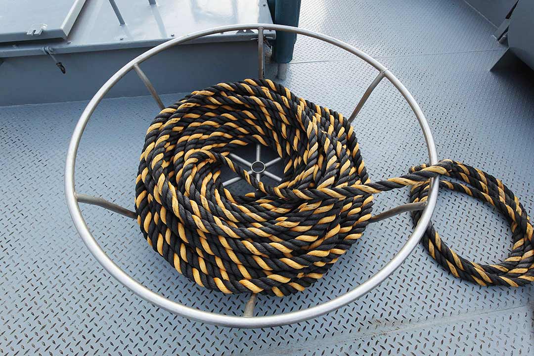 Aufgerolltes Tau in einem Taukorb an Deck