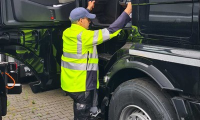 Mann steig in Lkw-Fahrerhaus ein