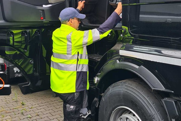 Ein Mann steigt in das Fahrerhaus eines Fernverkehrs-Lkw