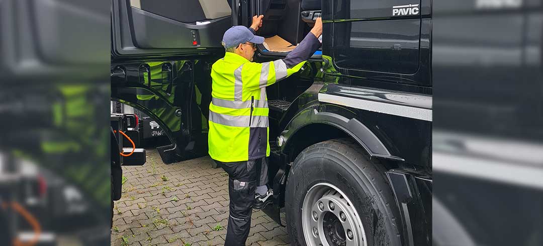 Ein Mann steigt in das Fahrerhaus eines Fernverkehrs-Lkw Ein Mann steigt in das Fahrerhaus eines Fernverkehrs-Lkw