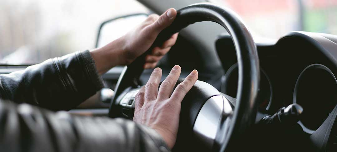 Ein Autofahrer drückt auf den Hupknopf eines Lenkrads. Ein Autofahrer drückt auf den Hupknopf eines Lenkrads.