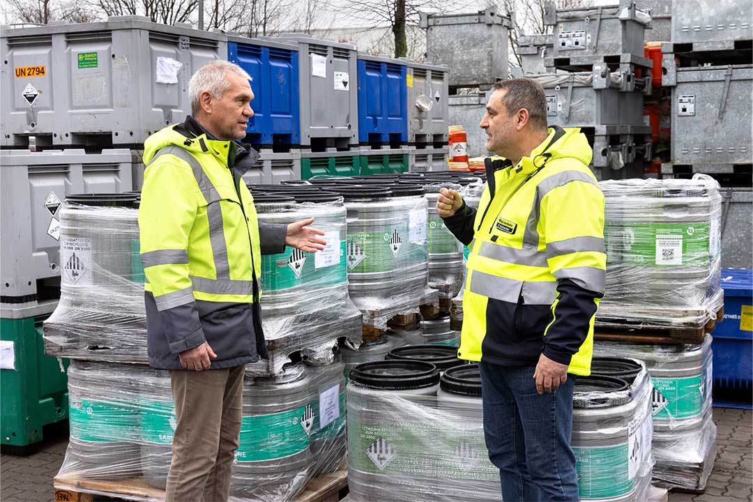 Zwei Männer in leuchtendgelber Warnjacke im Gespräch.