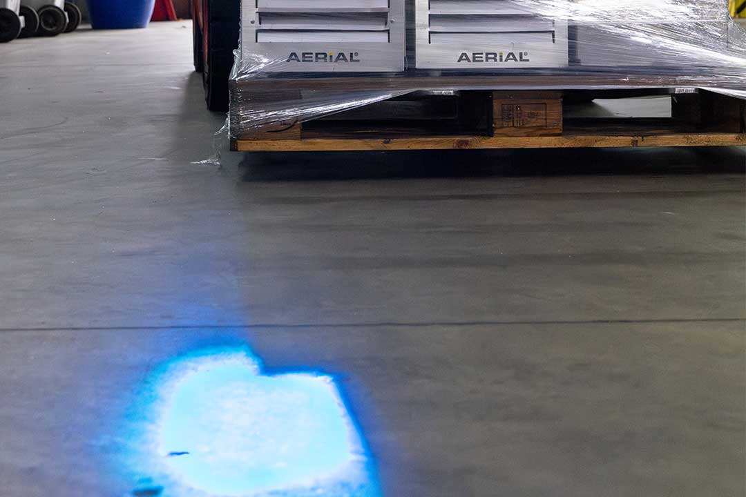 Mit den blauen Lichtpunkten kündigen sich die Gabelstapler an, um Zusammenstöße zu vermeiden.