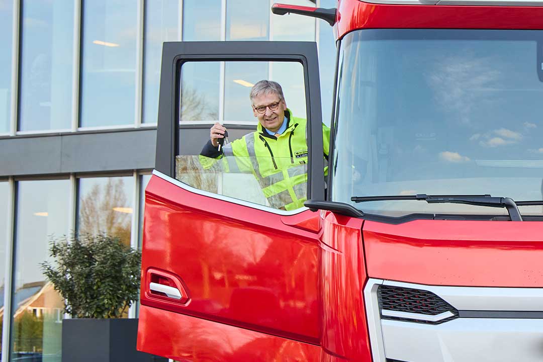 Dr. Jörd Hedtmann schaut aus einer geöffneten Lkw-Beifahrertür. Dr. Jörg Hedtmann steht an der offenen Beifahrertür eines Lkw und hält einen Schlüssel in die Höhe.