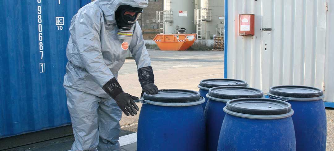 Im Zweifel schützen sich die Beschäftigten mit einem Anzug, Handschuhen und Gesichtsmaske Mitarbeiter in Schutzkleidung bei der Entsorgung von chemischen Abfällen