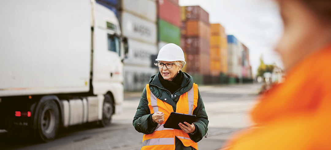 Mitarbeitende in Schuztkleidung vor einem Lkw