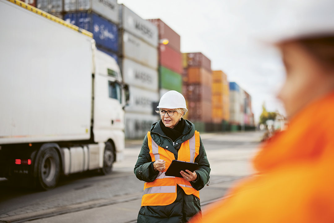 Mitarbeitende in Schuztkleidung vor einem Lkw