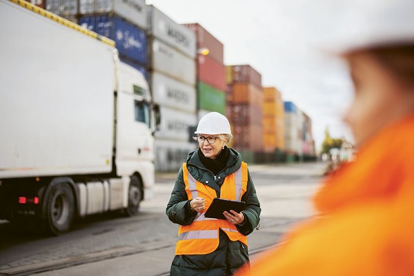 Mitarbeitende in Schuztkleidung vor einem Lkw