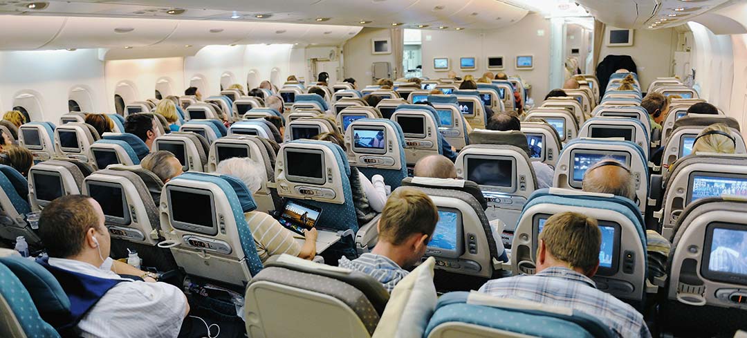 Einblick in einen vollen Airbus-Flieger mit Passagieren bei der Nutzung elektronischer Geräte