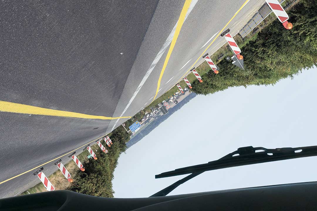 Blick durch die Windschutzscheibe eines umgekippten Lkw auf die Autobahn
