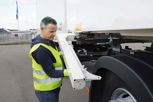 Mitarbeiter klappt die Beine eines Wechselbehälters aus
