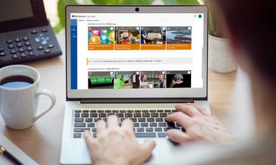 Laptop auf Schreibtisch mit Lernwelt der BG Verkehr auf Bildschirm