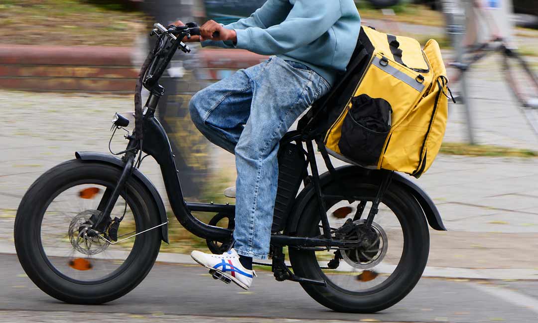 Ein Lieferdienstfahrer auf einem E-Bike