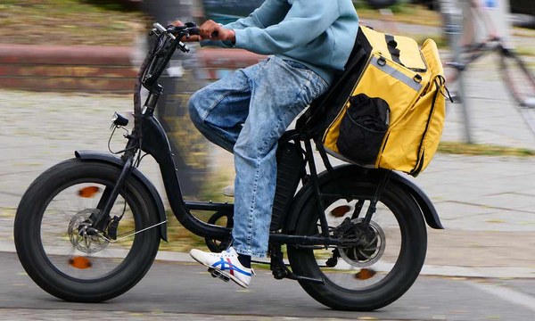 Ein Lieferdienstfahrer auf einem E-Bike