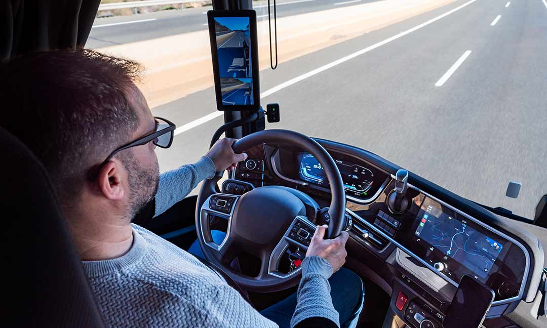 Mann sitzt am Lenkrad eines Lkw mit Spiegelersatzsystem
