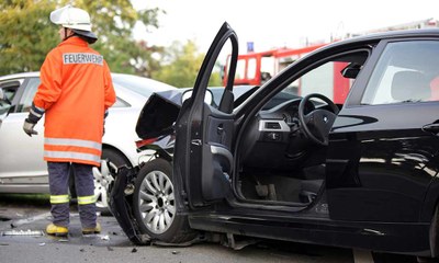 Feuerwehrmann bei Aufräumarbeiten nach Verkehrsunfall